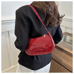 Bolso hobo rojo brillante combinado con blazer negro y falda plisada blanca