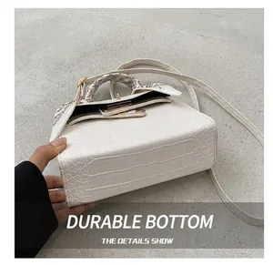 Detailed macro view of the wear-resistant base and crocodile pattern on this white handbag