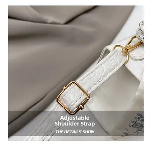 Detail of white stone pattern leather bag with adjustable strap and gold hardware