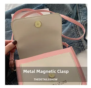 Detail of magnetic snap closure on a pink and white bicolor crossbody studio bag