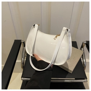 Primer plano del bolso hobo de charol blanco con cremallera dorada y correa minimalista