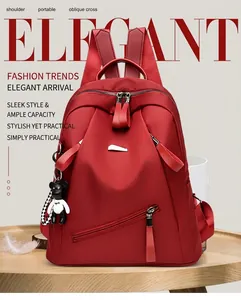 Detail of red multifunctional backpack with silver hardware and cute bear charm