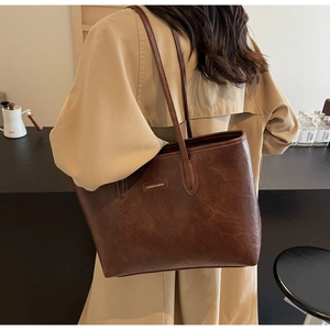 Close-up of vintage brown tote bag with premium leather texture and fashion brand tag