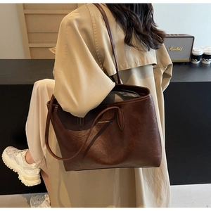 Detail of dark brown leather tote bag with long shoulder strap for daily commuting