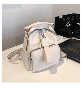 Close-up of creamy white litchi grain leather backpack with silver metal zippers