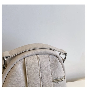 Detail view of cream PU leather top handle and neat stitching on fashion backpack