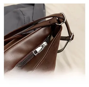 Detailed close-up of dark brown PU leather texture and silver zipper hardware on the tote