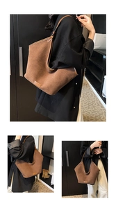 Detail of large brown textured tote bag featuring V-shaped opening and leather trim