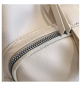 Close-up of beige pebble grain leather texture with premium silver zipper detail