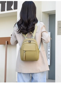 Close-up of olive green soft leather mini backpack with textured finish and adjustable straps