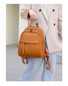 Detail of caramel soft leather backpack with stylish flap pocket and metal zippers