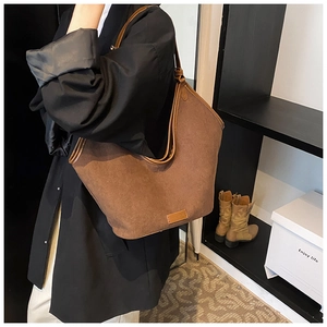 Detail of coffee brown faux suede tote bag featuring a minimalist Hobo style design