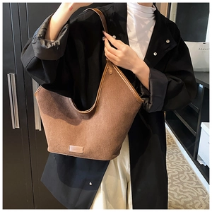Close-up of brown corduroy tote bag with leather trim and professional stitching detail