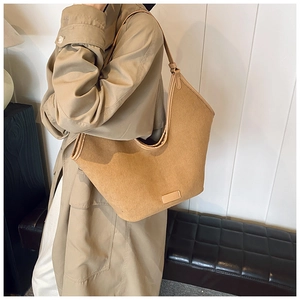 Detail of camel tote bag in textured wool fabric with slim leather shoulder straps