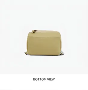 Detail view of the flat rectangular base on this mustard green faux leather backpack