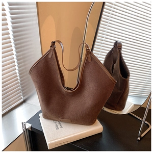 Detail of dark brown tote bag made of corduroy fabric showing the leather brand plate