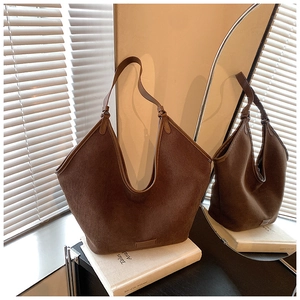 Detail of coffee brown corduroy tote bag with leather straps on a vintage book
