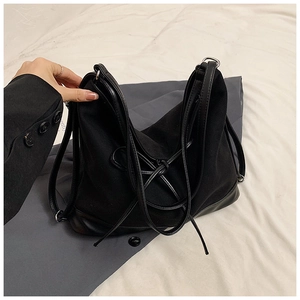 Large black canvas tote bag with faux leather base and knot detail for daily commuting