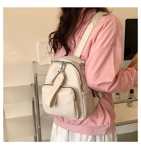Chic off-white faux leather backpack featuring a front pocket and soft lychee grain texture