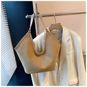 Detail view of khaki canvas tote bag with V-cut opening and subtle leather logo patch