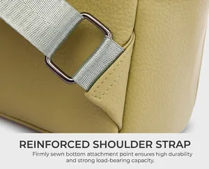 Detailed close-up of yellow leather bag showing reinforced stitching and metal buckle