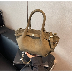 Detailansicht einer olivgrünen mattierten Handtasche mit Vintage-Metallschnalle und Gurt