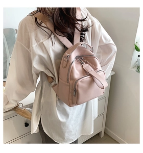 Detail of light pink mini backpack with litchi grain PU leather and silver zippers