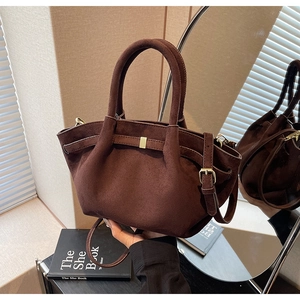 Detail der dunkelbraunen Wildleder-Beuteltasche mit Seitenfalten und Metallschnalle