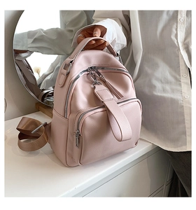 Detail of pink faux leather mini backpack featuring litchi grain texture and front pocket