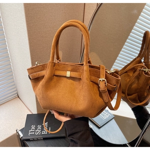 Detail der karamellbraunen Wildledertasche mit goldener Schnalle und Umhängeriemen