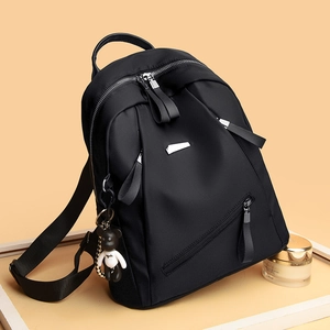 Women's black nylon backpack with silver zippers and cute bear charm for daily commute
