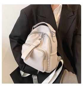 Close-up of cream PU leather mini backpack with pebble texture and adjustable straps
