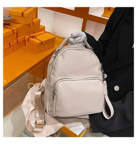 Close-up of beige lychee pattern faux leather backpack with multiple zip pockets