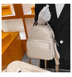 Detail of creamy beige lychee grain PU leather backpack with silver metal hardware