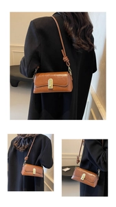 Détail d'un sac bandoulière vintage en cuir marron avec fermoir doré et bandoulière nouée