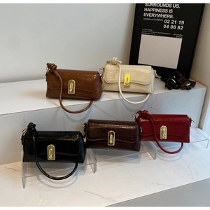 Gros plan de sacs baguette vintage en cinq couleurs avec boucles métalliques dorées