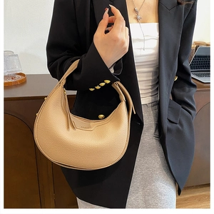 Close-up of beige lychee texture leather hobo bag with gold hardware and logo