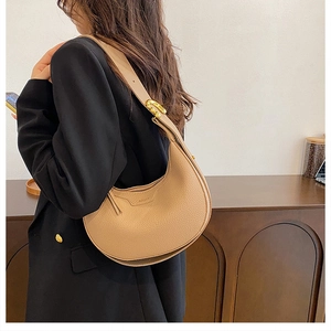 Close-up of litchi grain leather shoulder bag with adjustable gold buckle strap