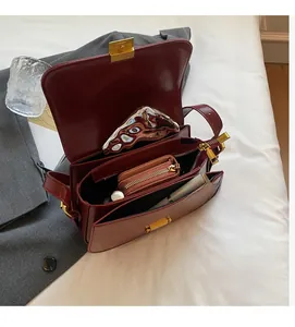 Interior view of wine red leather bag with double compartments and secure gold lock