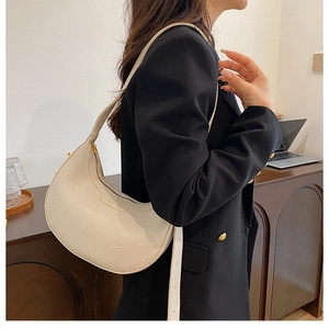 Detail of creamy white pebble leather hobo bag with gold zipper and adjustable strap