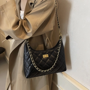 Classic black quilted leather tote bag with gold chain strap shown on a model