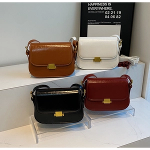Detail of four retro flap crossbody bags in brown, white, black, and wine red with gold buckles