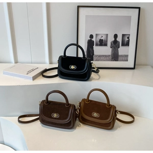 Three retro matte crossbody bags in black and brown on minimalist white stairs