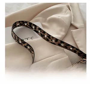 Détail du sac léopard avec œillets métalliques sur la bandoulière de style vintage