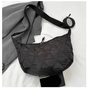 Dettaglio borsa a mezzaluna trapuntata nera con tracolla regolabile e mini astuccio