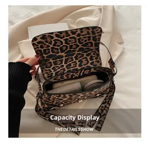 Vue intérieure du sac bandoulière léopard montrant la capacité pour téléphone et maquillage