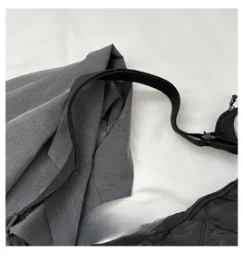 Dettaglio della borsa tote in nylon nero con trapuntatura a rombi e tracolla in tessuto