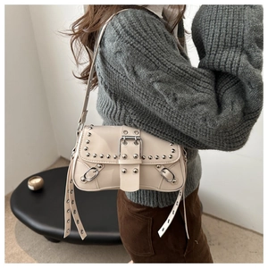 Détail du sac en cuir blanc crème avec rivets argentés et boucles métalliques