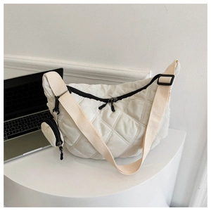 Dettaglio della borsa a tracolla trapuntata beige con portamonete rotondo abbinato