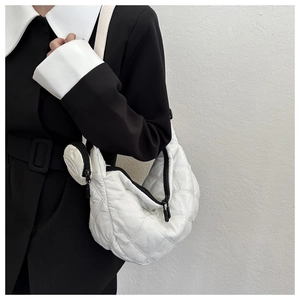 Dettaglio borsa trapuntata bianca in nylon con zip nera e ciondolo portamonete rotondo